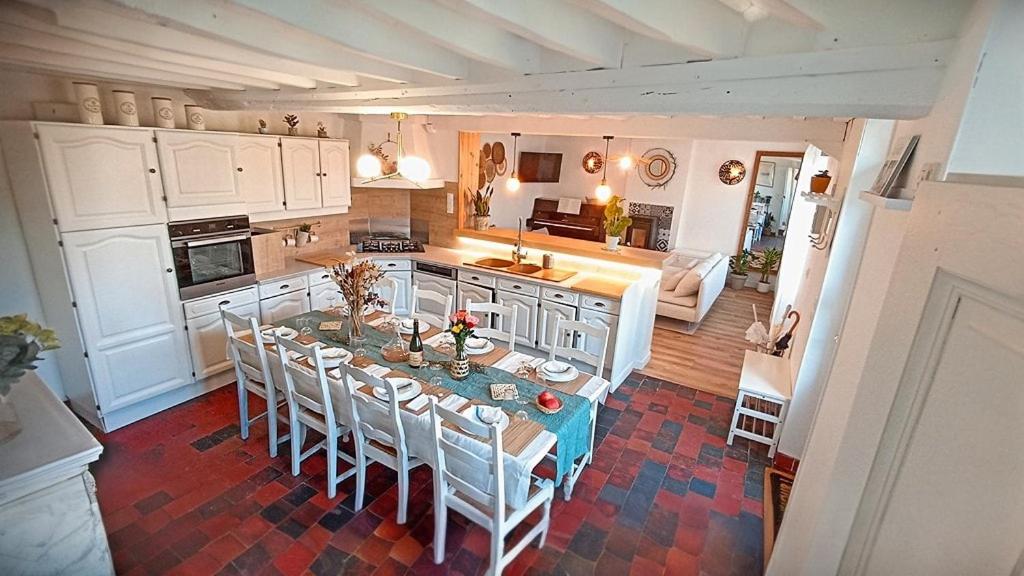 une cuisine avec une table et des chaises dans une pièce dans l'établissement Séjour familial haut de gamme spa et confort près des plages du Débarquement, à Sommervieu