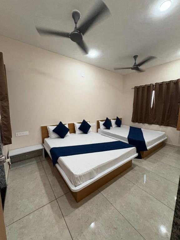 德瓦尔卡Hotel Darshan Palace - Near Dwarka Railway Station & Shree Dwarkadhish Temple的一间卧室，有两张床，配有蓝色枕头