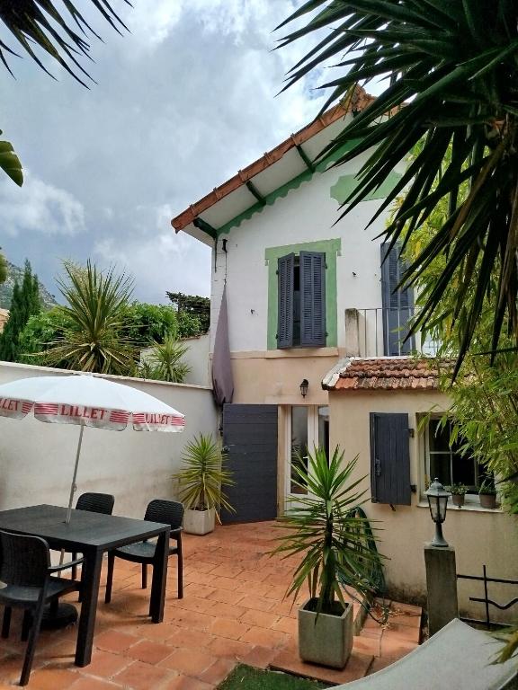 une maison avec un patio avec une table et des chaises dans l'établissement Maisonette avec jardinet sur le bas du Faron, à Toulon