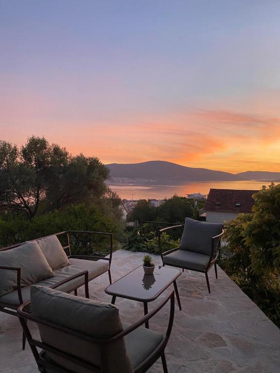 a patio with couches and a table and a sunset at Villa Antonia in Tivat