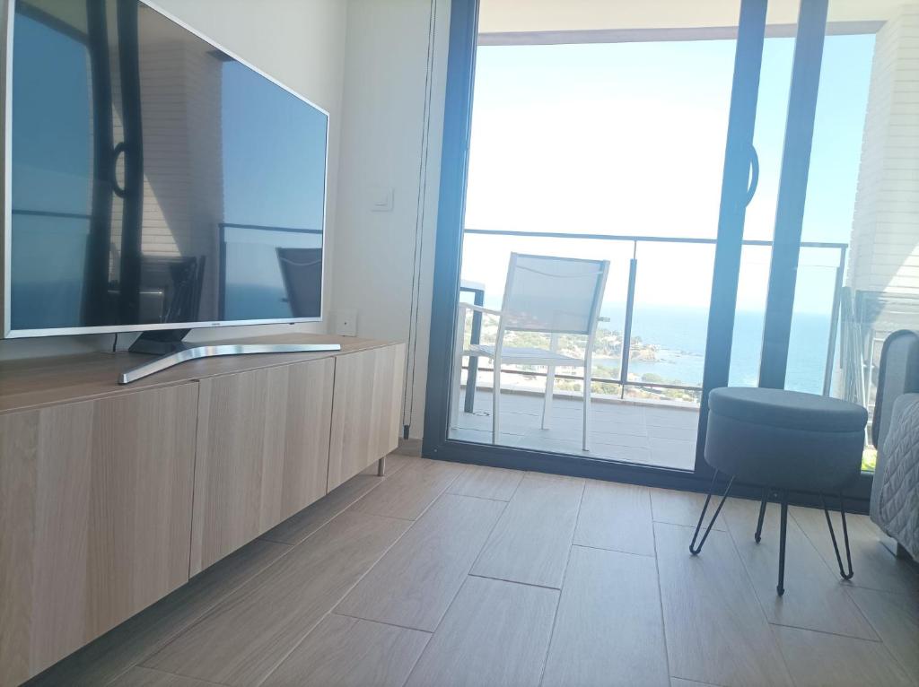 Televízia a/alebo spoločenská miestnosť v ubytovaní Apartament vistes al mar