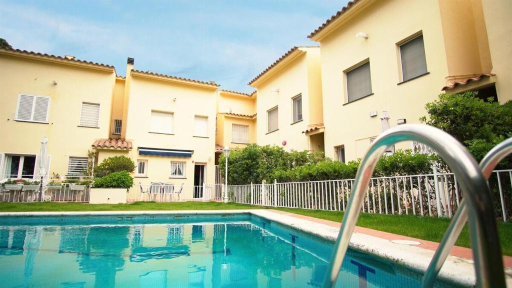 a swimming pool in front of two apartment buildings at Villa Nuria by HR COSTABRAVA in Platja d'Aro