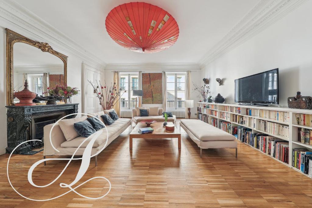 un salon avec un canapé et une télévision dans l'établissement Philosophy, luxury apartment for 6 in Madeleine, à Paris