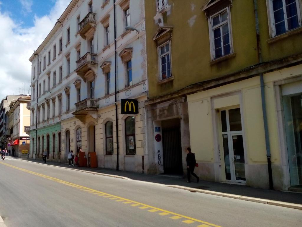 a man walking down a street next to a building at Dejan Apartment-Top centar with Private parking in Pula