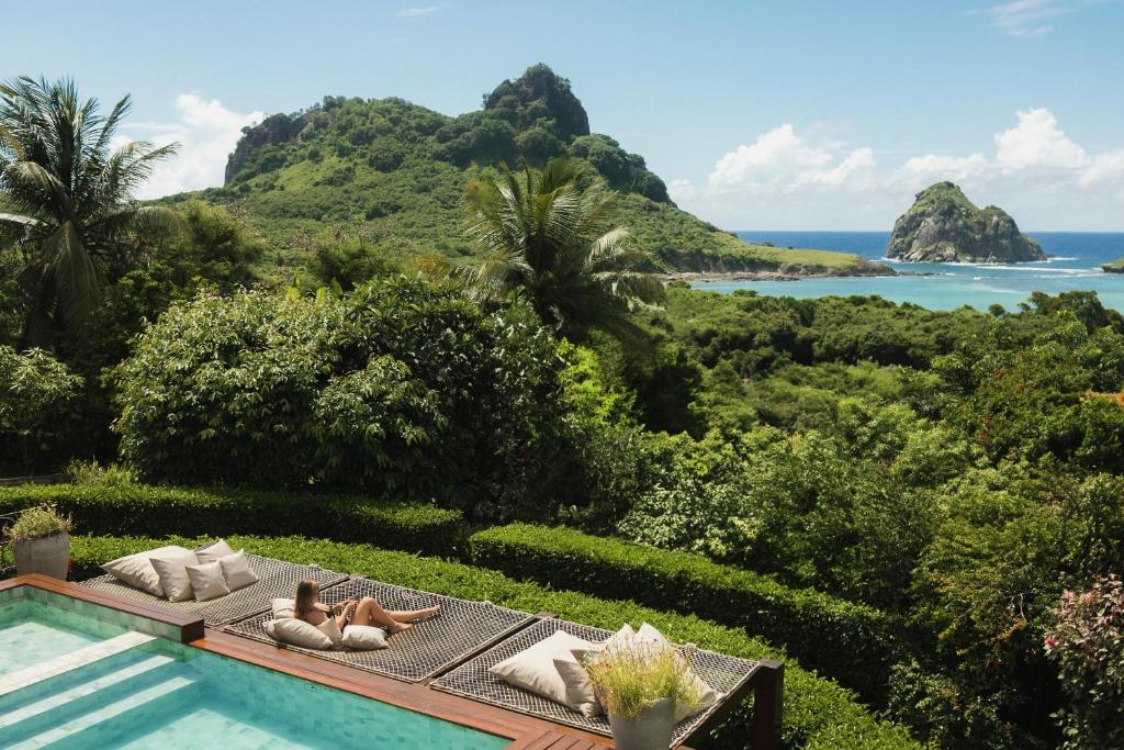 a resort with a pool and a view of the ocean at Pousada Maravilha in Fernando de Noronha