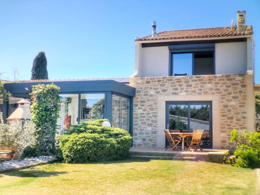 une maison avec une table et des chaises dans une cour dans l'établissement Les Pieds dans Thau, à Marseillan