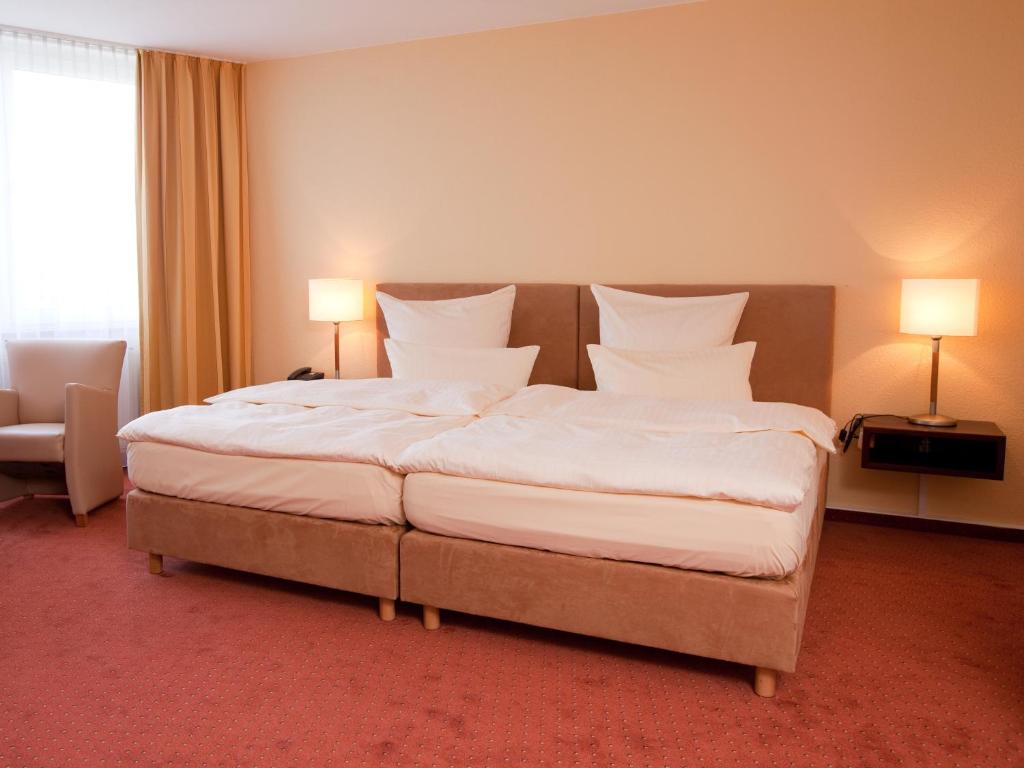 Postel nebo postele na pokoji v ubytování Carathotel Basel/Weil am Rhein