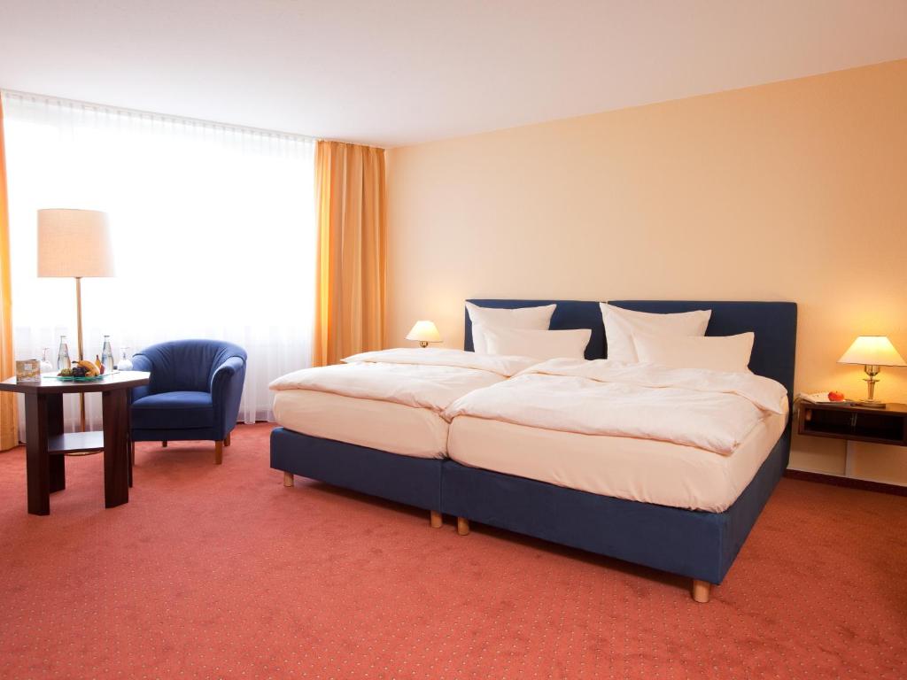Postel nebo postele na pokoji v ubytování Carathotel Basel/Weil am Rhein