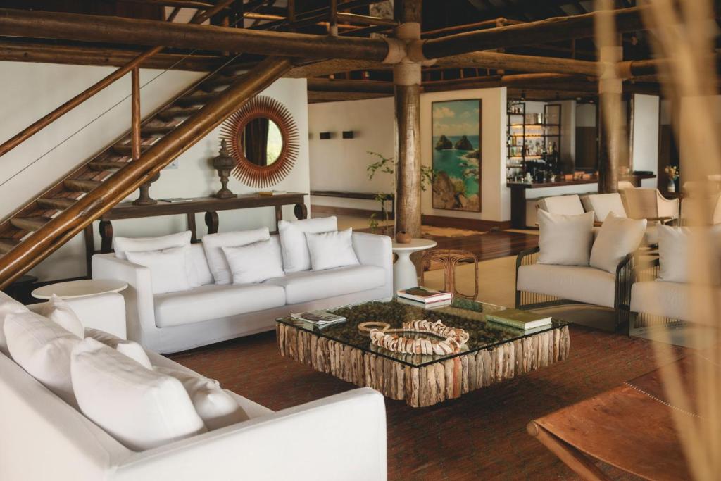 a living room with white couches and a table at Pousada Maravilha in Fernando de Noronha