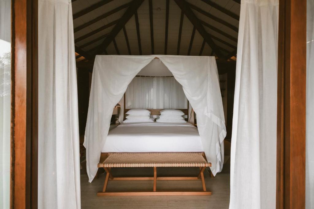a bed with white sheets and pillows in a tent at Pousada Maravilha in Fernando de Noronha