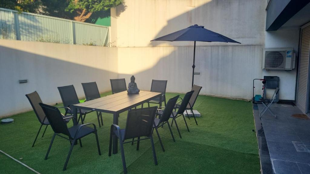 un tavolo e sedie con ombrellone su un prato di Charmy Villa Estoril by Amber Star Rent a Cascais