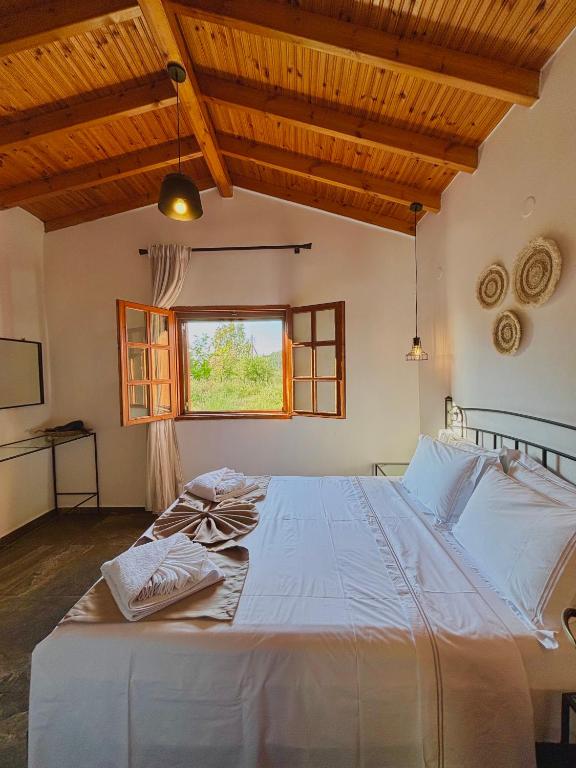 a large white bed in a room with a window at MK Rustic Stays in Neos Marmaras