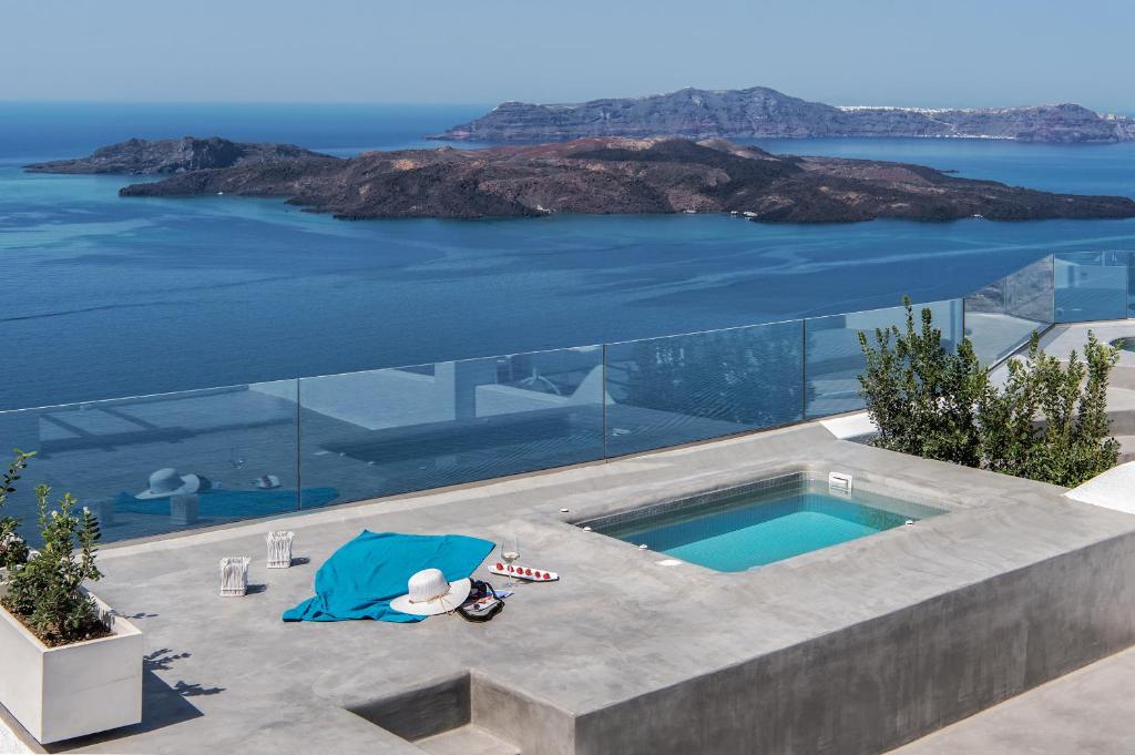 a swimming pool on top of a house with the ocean at Villa Irini Fira - Adults Only in Fira
