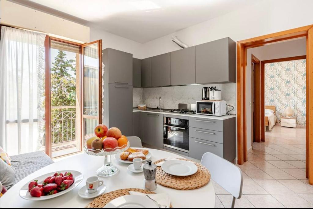 a kitchen with a table with a bowl of fruit on it at Appartamento sul Porto di Bellaria Igea Marina in Bellaria-Igea Marina
