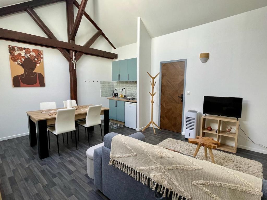 un salon avec une table et une salle à manger dans l'établissement Le Nid de l'Artiste - Reims Cathedral City Center, à Reims