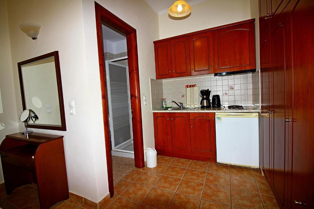 a kitchen with red cabinets and a white refrigerator at Artemis Traditional Hotel in Myrina