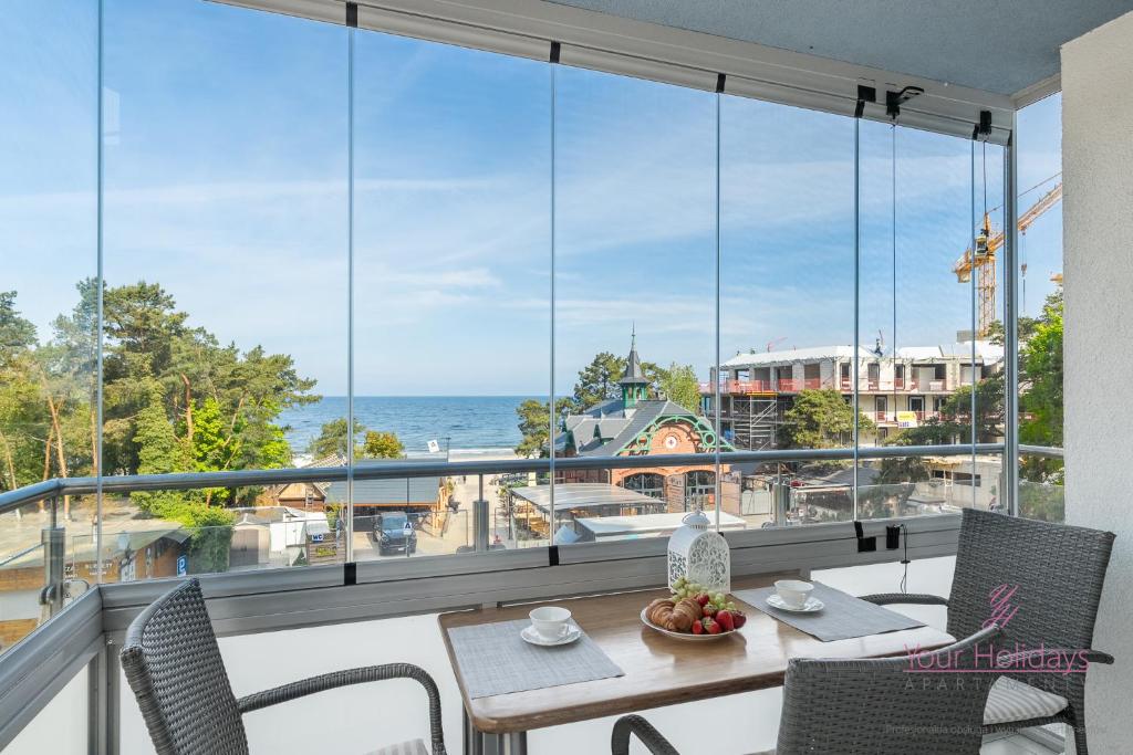 a balcony with a table and chairs and a view of the ocean at Your Holidays Campingowa in Międzyzdroje