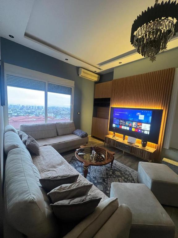 a living room with a couch and a tv at FOUR L's in Arape-Rashbulli