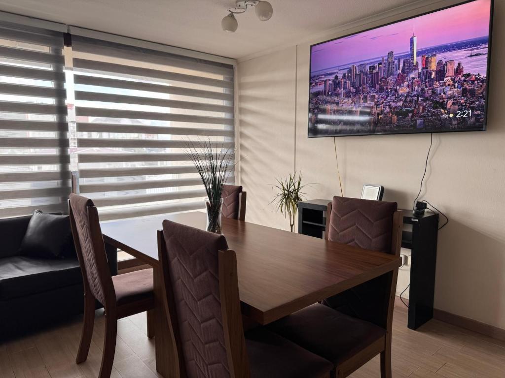 une salle à manger avec une table et une télévision murale dans l'établissement Edificio Claro Solar - Moderno Apartamento Centro Temuco 2D2B Parking, à Temuco