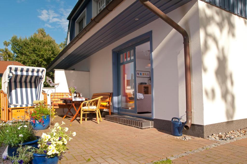 a patio with chairs and a table and a door at Ferienhaus Laran in Zingst