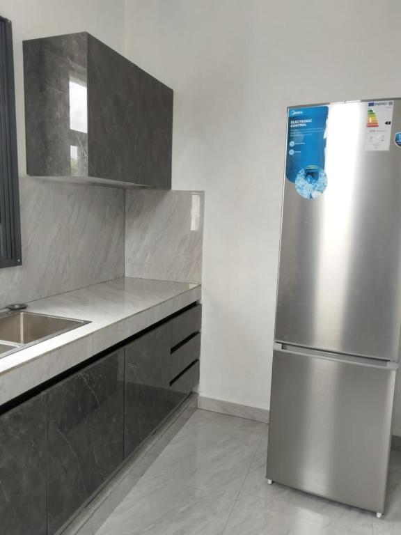 a kitchen with a stainless steel refrigerator and a sink at Kalyan Villa in Pointe aux Piments