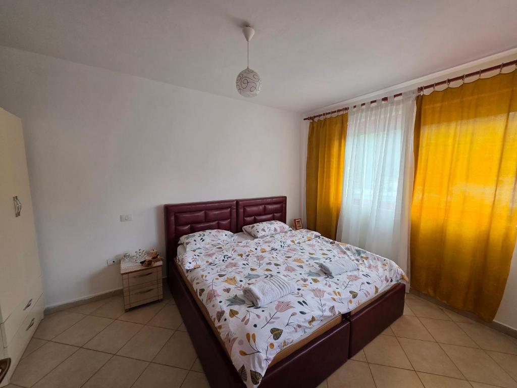a bedroom with a bed and a window with curtains at Volga Cozy Apartment in Durrës
