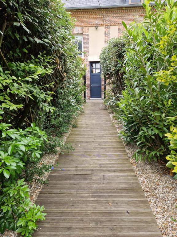 un chemin en bois menant à une maison avec une porte bleue dans l'établissement Studio des Enfants, à Honfleur