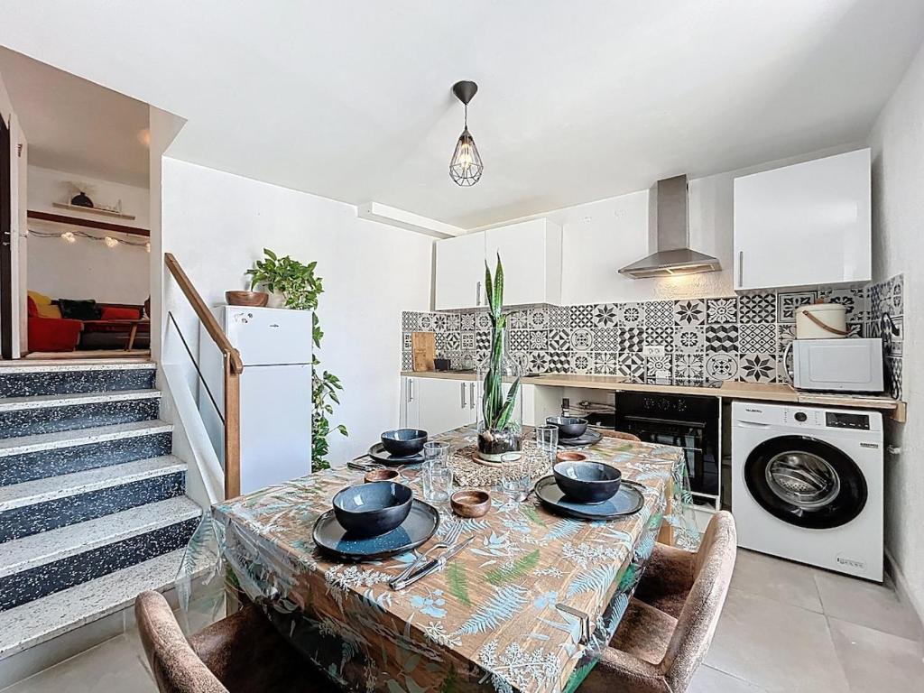 d'une cuisine avec une table et des bols. dans l'établissement Le Bohja - Charming apartment near Les Halles, à Narbonne