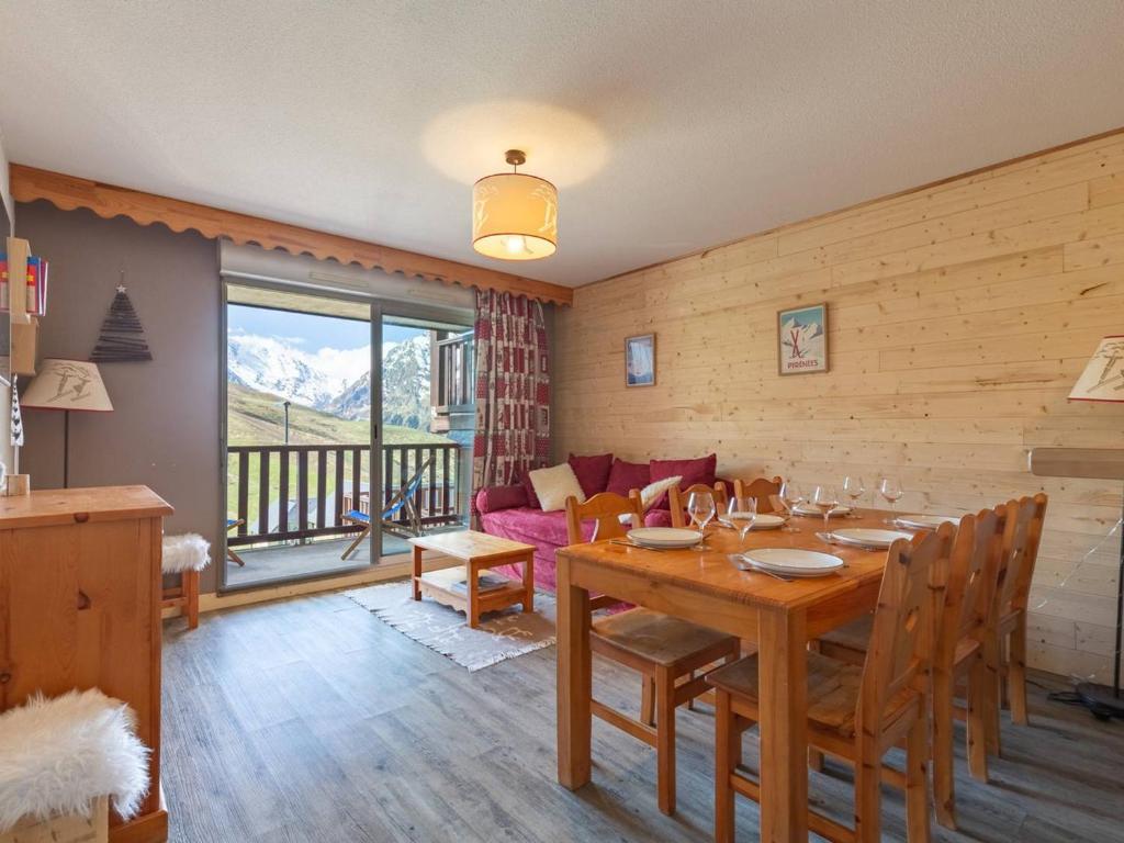 a dining room with a table and a couch at Appartement 8 pers Peyragudes, Wifi, Parking, Navette proche - FR-1-695-66 in Gouaux-de-Larboust