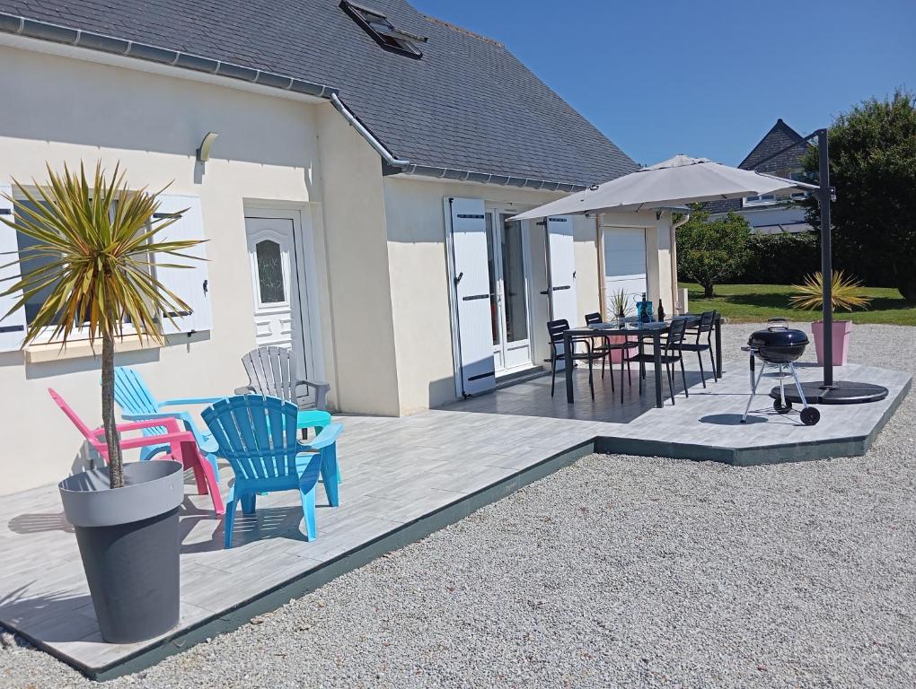 un patio avec une table, des chaises et un parasol dans l'établissement Villa Roz Veur, à Crozon