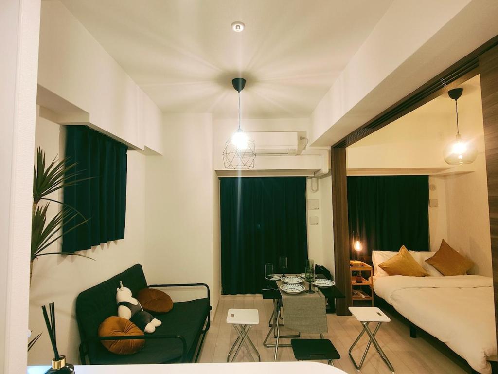 a living room with a bed and a couch at 無料駐車場付き恵美須町駅から190mあたたかくておしゃれな家 in Osaka