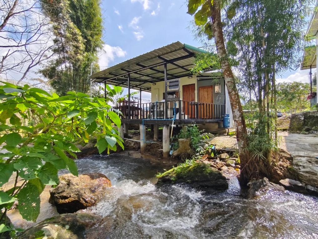 una casa con un río delante de ella en อินทนนท์ บ้านพักเล่าจู Inthanon Laoju House, en Ban Na Yang