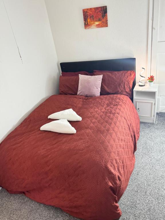 a bedroom with a large red bed with two pillows at Premium Cozzy Corner in Leicester