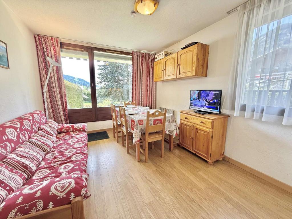 - un salon avec une table, un canapé et une télévision dans l'établissement 3 pièces avec terrasse et parking à Praz-Sur-Arly - 900m des pistes - FR-1-603-109, à Praz-sur-Arly