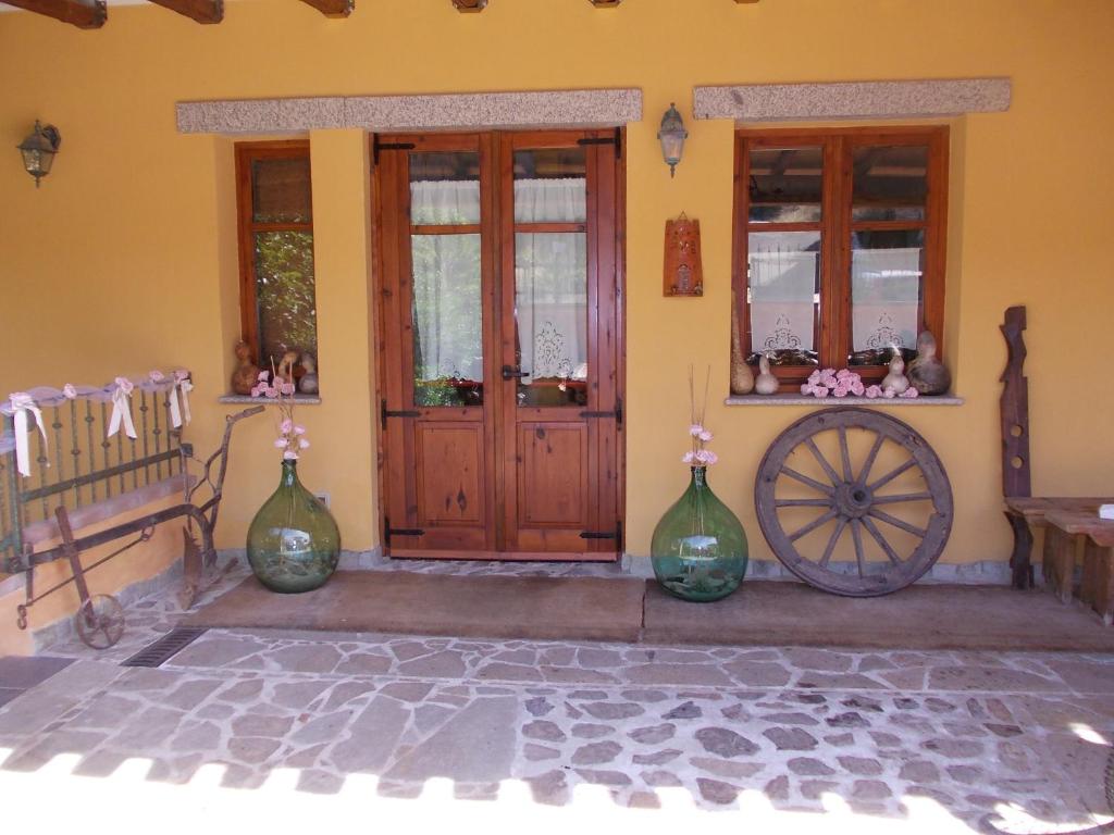 a house with two vases and a wooden door at B&B San Leonardo in Muravera