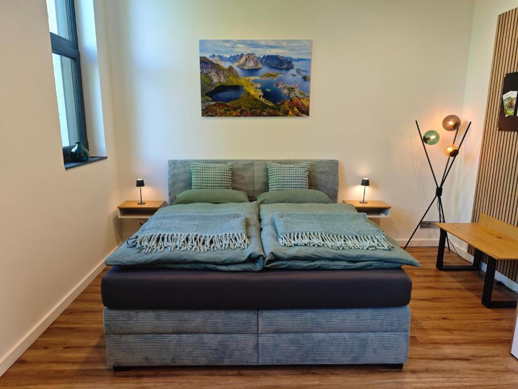 a bed in a room with a painting on the wall at Nordloft Bad Nenndorf in Bad Nenndorf