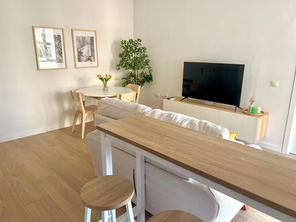 una sala de estar con un sofá y una mesa en Sol, centro y playa, en Almería
