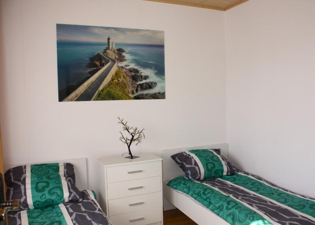 una camera con due letti e un dipinto sul muro di Ostoja Konarzewo a Pogorzelica