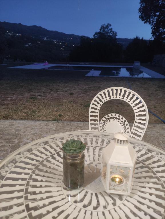 un tavolo bianco con una candela e una pianta sopra di Retiro Maria Idalina ad Amarante