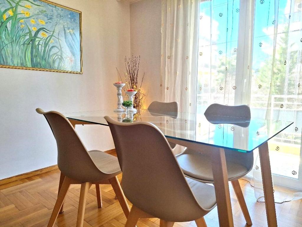 a dining room table with chairs and a glass table at Carlito apartment 1 next to metro station in Athens