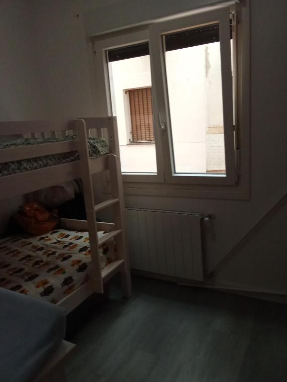 a bedroom with a bunk bed and a window at Habitación in Bilbao