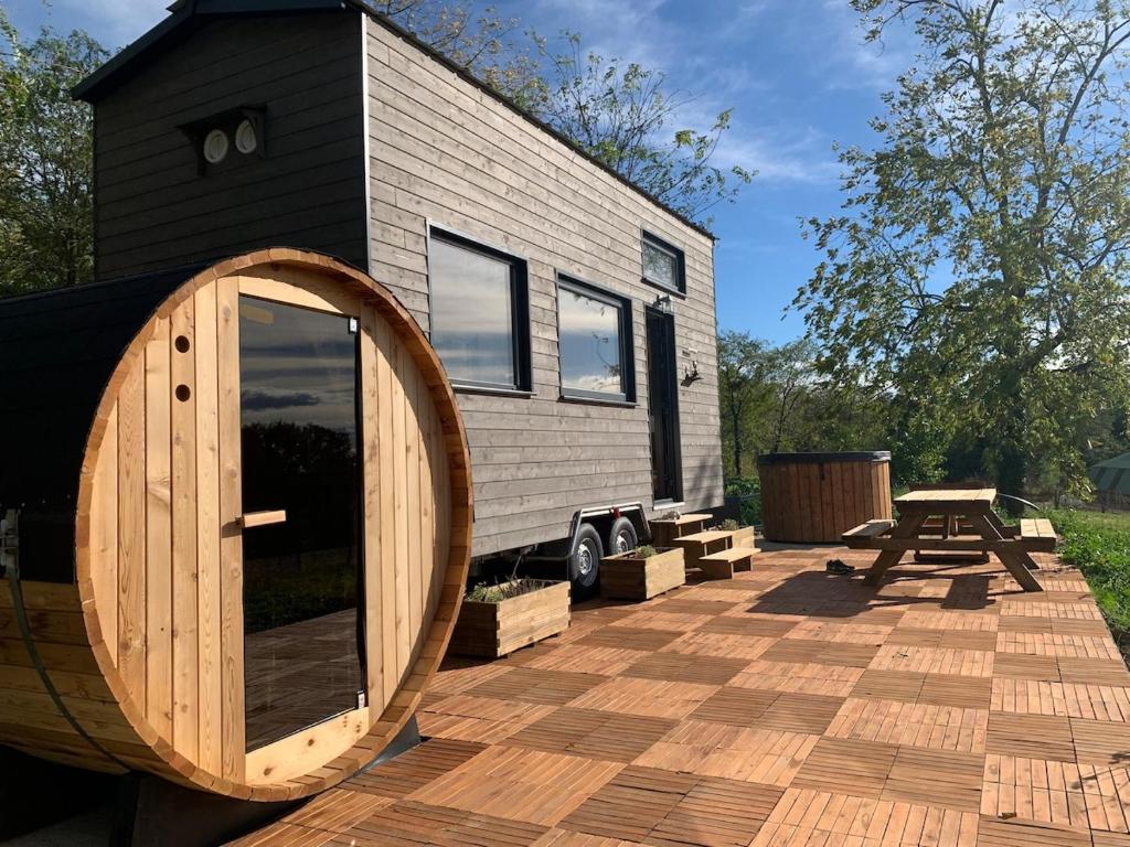 Una pequeña casa con una puerta de madera en una terraza. en Tiny House Lou Cabanot, en Goos