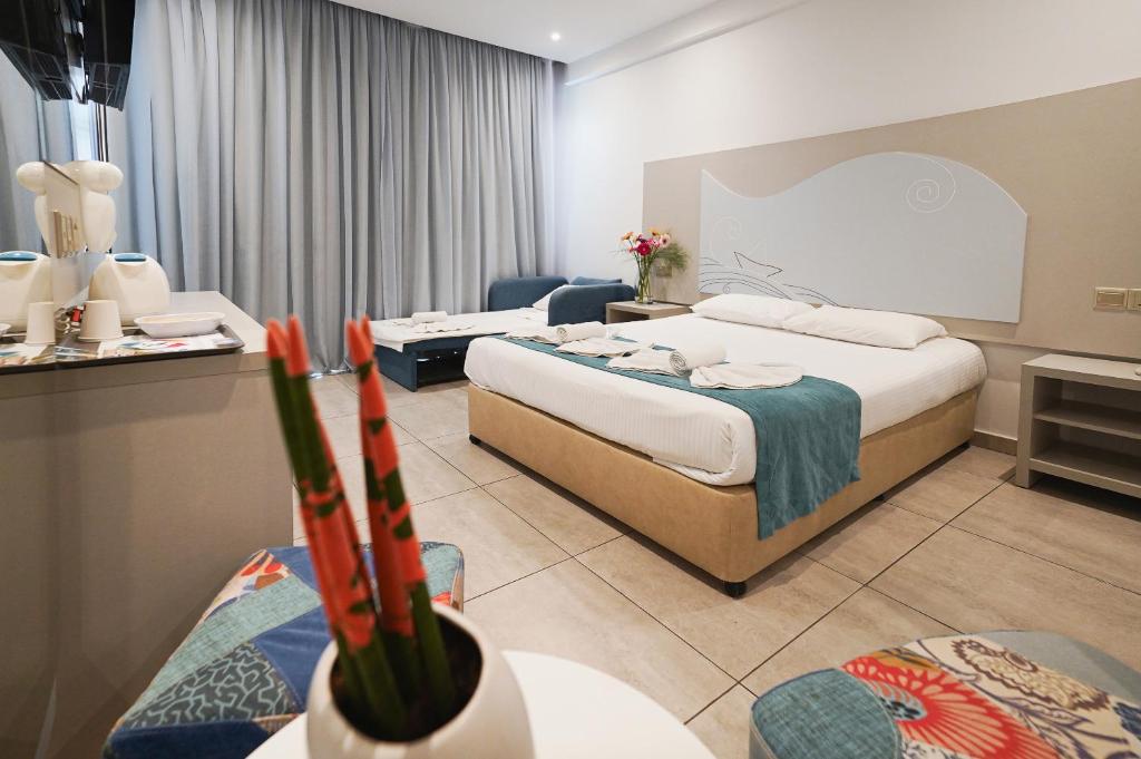 a hotel room with two beds and a couch at Nicholas Color Hotel in Ayia Napa