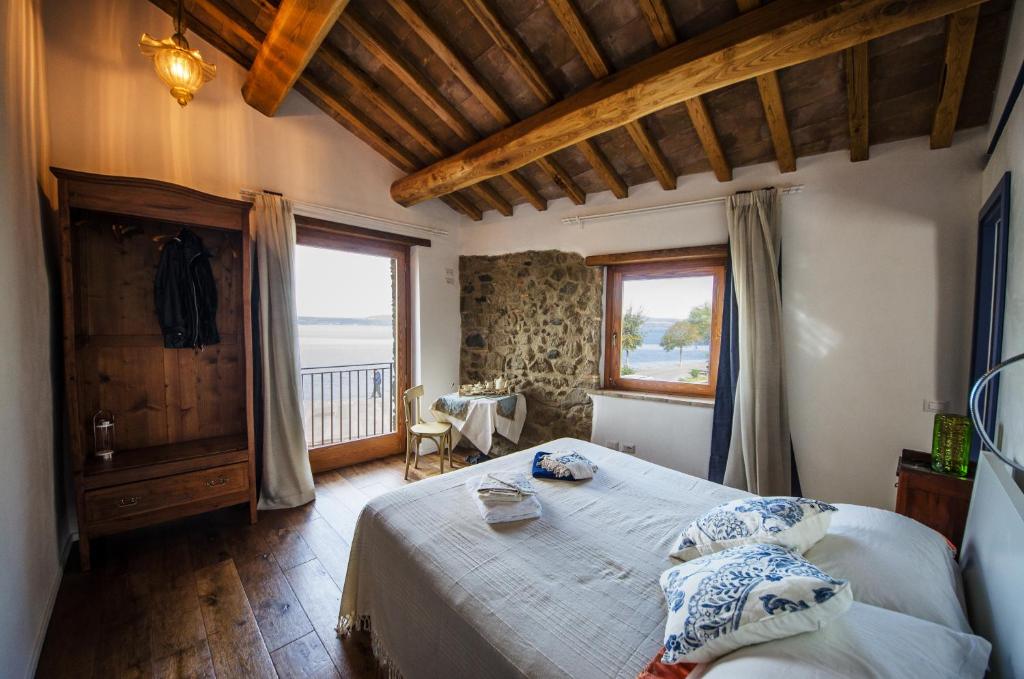 a bedroom with a large bed and a large window at Al Vicolo dei Pescatori in Anguillara Sabazia