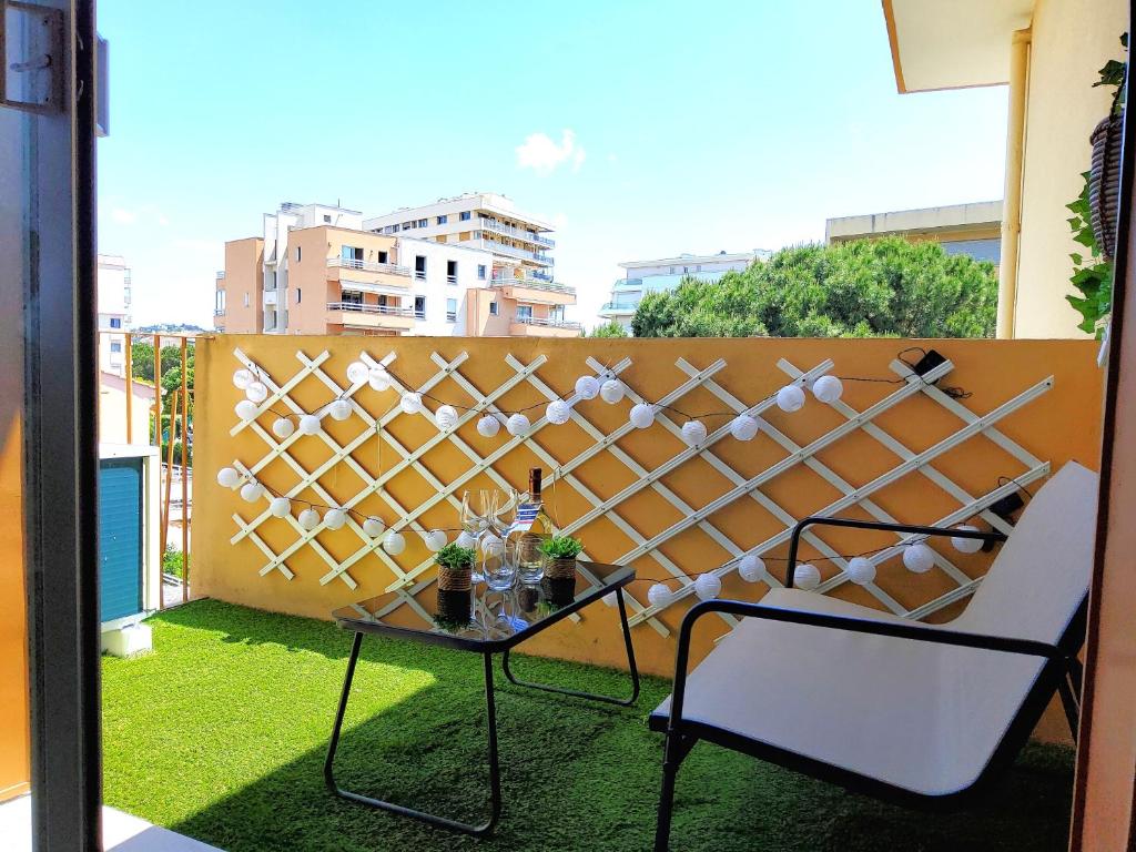 d'une table et d'une chaise sur un balcon avec une clôture. dans l'établissement 30m2 - Clim - wifi - 100m des plages, à Fréjus
