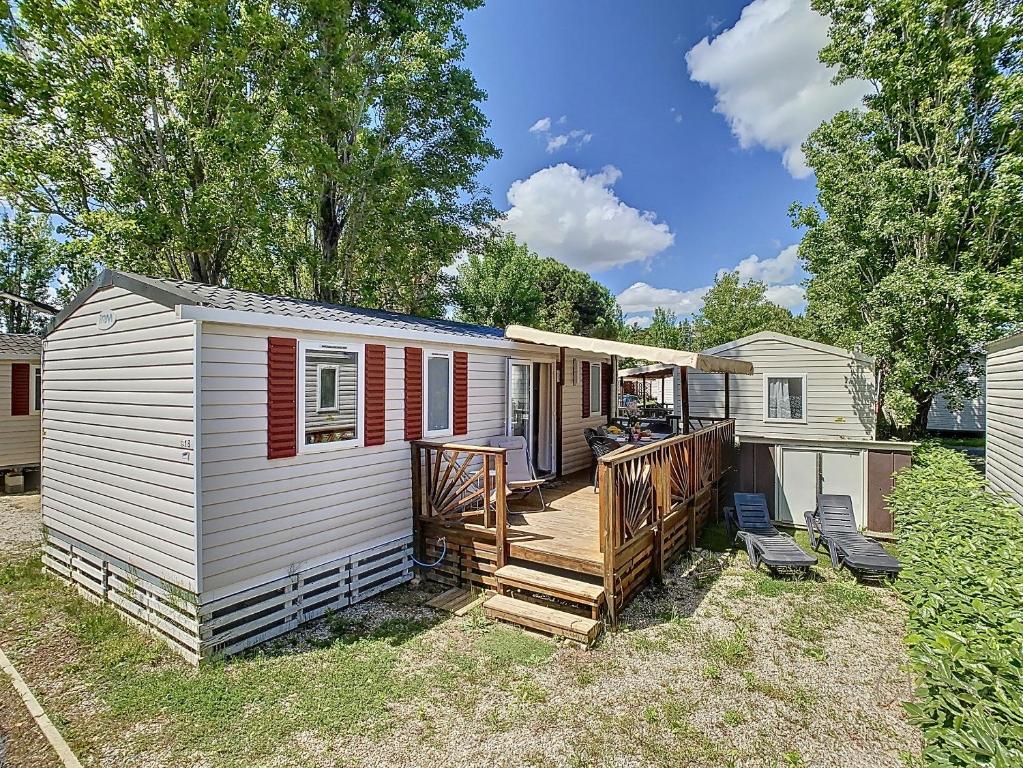 une petite maison avec un porche et une terrasse dans l'établissement Mobil-Home CL 18 à Vias - La Carabasse - Camping Siblu avec piscine, à Vias