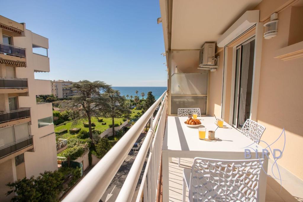un balcon avec une table et des chaises et l'océan dans l'établissement Cozy renovated apartment with sea view, à Cannes