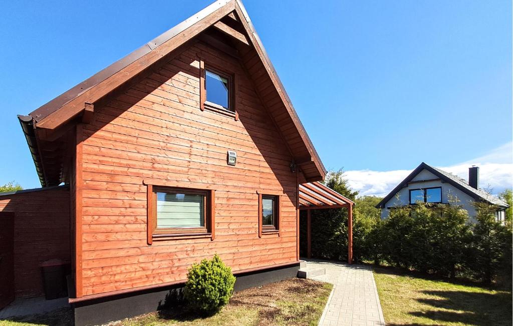 a small wooden house with a gambrel roof at Two-Bedroom Holiday Home In Podamirowo in Podamirowo