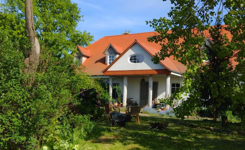a white house with an orange roof at Agroturystyka Rawiczówka in Brzeżno