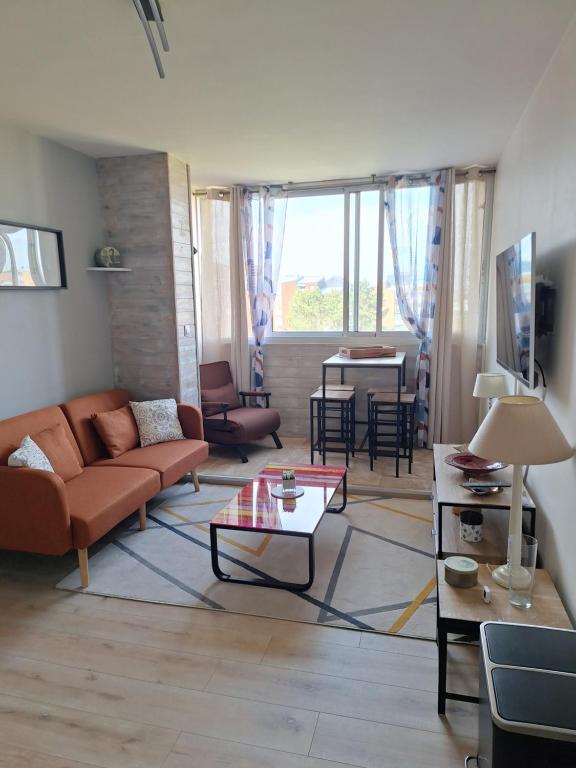 un salon avec un canapé et une table dans l'établissement Mer et sable, à Cabourg